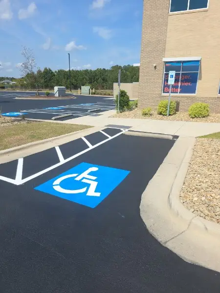 Freshly painted ADA handicap parking symbol and blue stall markings at a Charlotte NC property