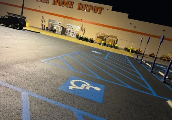 Nighttime ADA handicap parking stall striping with blue access aisles at a Charlotte NC retail store