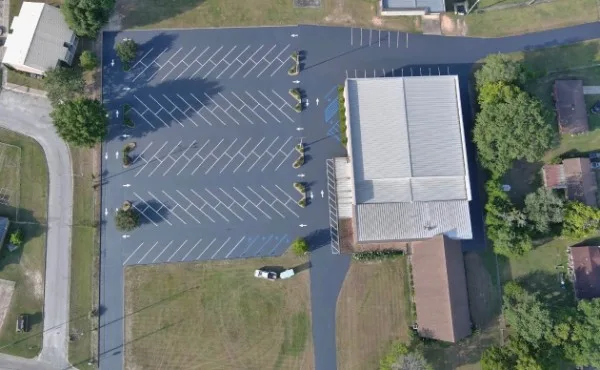 Aerial view of a freshly sealed and striped church parking lot with ADA stalls in Charlotte NC