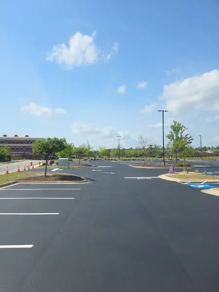 Commercial asphalt sealcoating contractor applying protective sealer to a Charlotte NC parking lot
