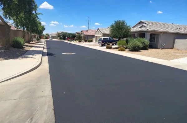 Freshly sealcoated HOA residential street with a uniform black asphalt finish in Charlotte NC