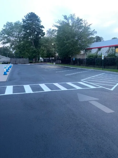 Directional arrow, zebra crosswalk, and stall striping on a freshly sealed Charlotte NC parking lot